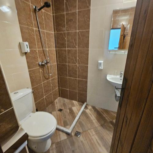 a bathroom with a shower and a toilet and a sink at Guest House Belchin View in Belchin