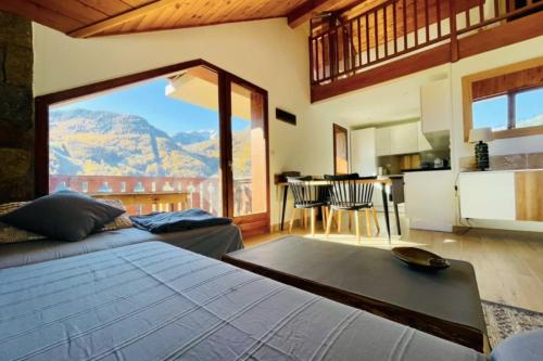 un salon avec un lit et une grande fenêtre dans l'établissement Nice apartment with 2 balconies and view, à La Salle Les Alpes