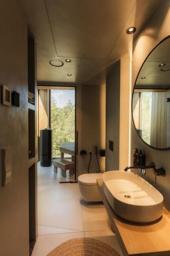 a bathroom with a tub and a sink and a mirror at Dharma Resort in Rässa