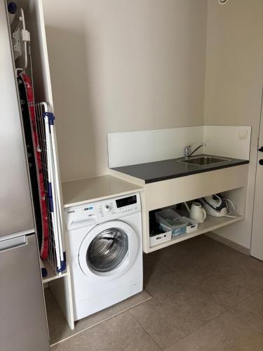 a small kitchen with a washing machine and a sink at Time 4 Time in Roesbrugge-Haringe