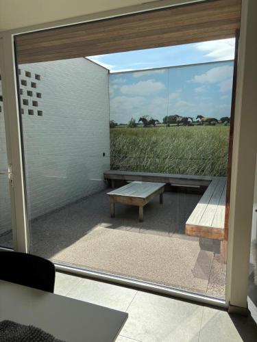 a window with a bench and a view of a field at Time 4 Time in Roesbrugge-Haringe