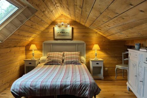 une chambre avec un lit dans une pièce aux murs en bois dans l'établissement Pretty cottage with Wifi by the sea, à Baden