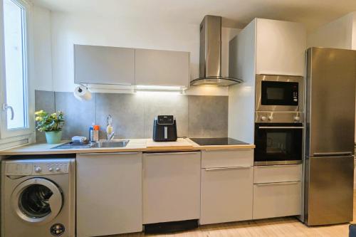 Il comprend une cuisine équipée d'un réfrigérateur et d'un lave-linge/sèche-linge. dans l'établissement Bright apartment near the beach, à Toulon