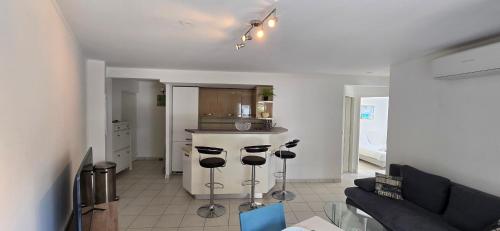 un salon avec un canapé et une cuisine dans l'établissement Comfortable apartment near the sea, à Sainte-Maxime