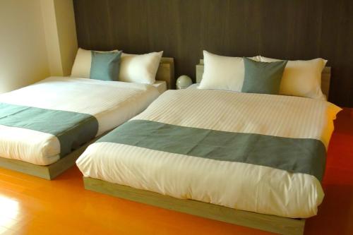 two beds sitting next to each other in a room at Kototoki-Ren-401 Deluxe Family Suite room in Hiroshima