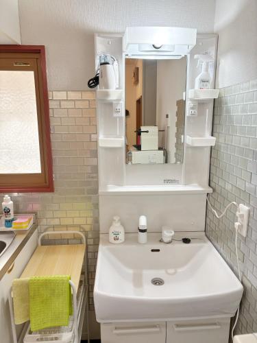 a bathroom with a white sink and a mirror at 和宿 湯沢チャオ Wayado Yuzawa Ciao in Yuzawa