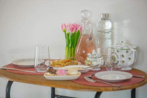 a table with plates and glasses and flowers on it at Cosy apartments in Análipsis