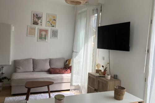 un salon avec un canapé et une télévision à écran plat dans l'établissement Apartment with terrace near Montmartre, à Paris