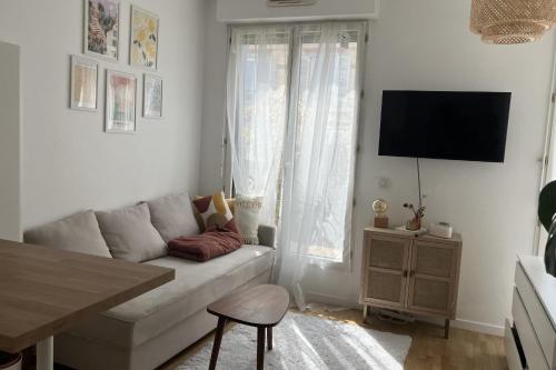 un salon blanc avec un canapé et une télévision dans l'établissement Apartment with terrace near Montmartre, à Paris