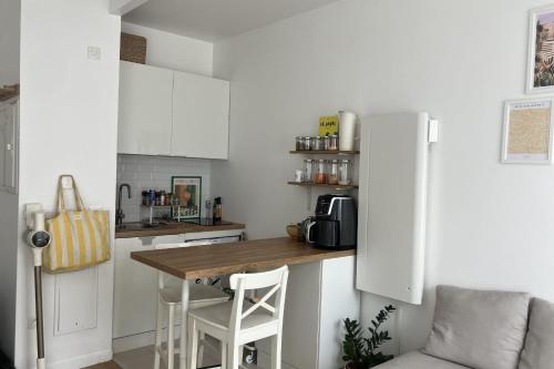 une petite cuisine avec une table et un réfrigérateur dans l'établissement Apartment with terrace near Montmartre, à Paris