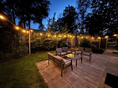 a patio with a table and chairs and lights at Holiday Home Maridu Wellness in Arnhem