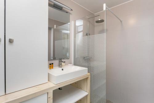 une salle de bain avec un lavabo et une douche dans l'établissement appartement face à la mer avec parking, à Palavas-les-Flots