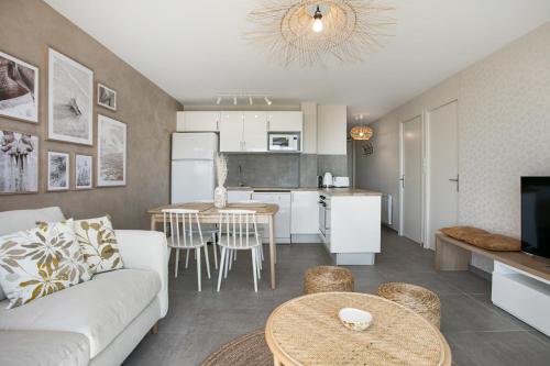 un salon et une cuisine avec un canapé et une table dans l'établissement appartement face à la mer avec parking, à Palavas-les-Flots