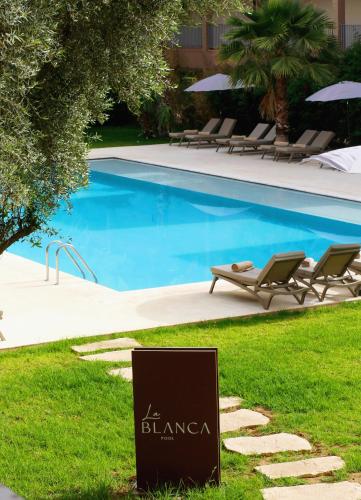 a sign in the grass next to a swimming pool at Rawabi Hotel Marrakech & Spa in Marrakech