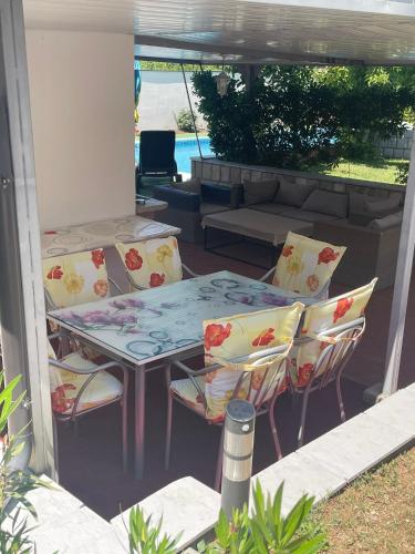 eine Terrasse mit einem Tisch, Stühlen und einem Sofa in der Unterkunft Kuca Magnolia Blagaj in Blagaj