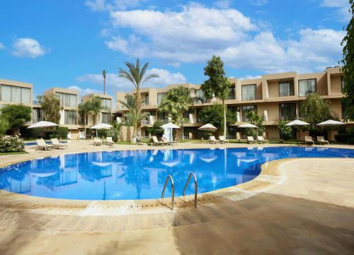 a large swimming pool in a resort with umbrellas at Rawabi Hotel Marrakech & Spa in Marrakech