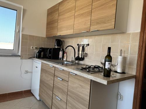 a kitchen with a sink and a counter with a bottle of wine at Apartment Luxury B Vodice in Vodice