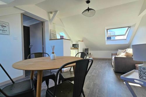 - une table à manger et des chaises dans le salon dans l'établissement Apartment for 4 - near hypercentre, à Vannes