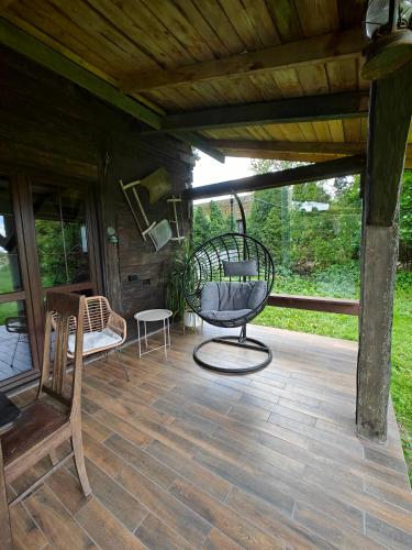 a screened in porch with a chair and a swing at Stay At This Magnificent 100 Year Old Barn in Ruciane-Nida