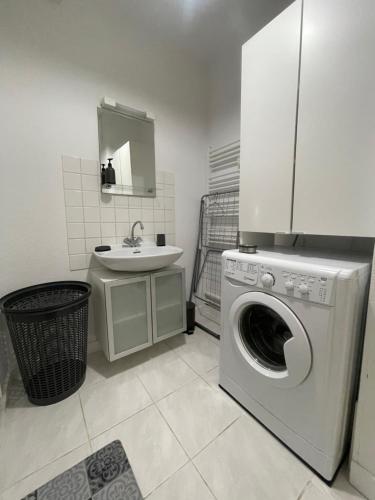 a bathroom with a washing machine and a sink at La légende Men Marz 1er étage- Centre-ville Brignogan-Plages , 300 m des plages in Brignogan-Plages