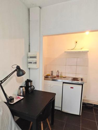 - une petite cuisine avec une table et un comptoir dans l'établissement Jojo appartement 1 chambres Paris-La défense, à Puteaux