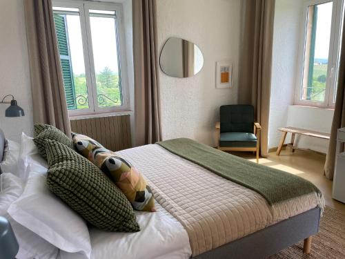 a bedroom with a bed and a chair and windows at Agriturismo Tenuta la Marchesa in Novi Ligure