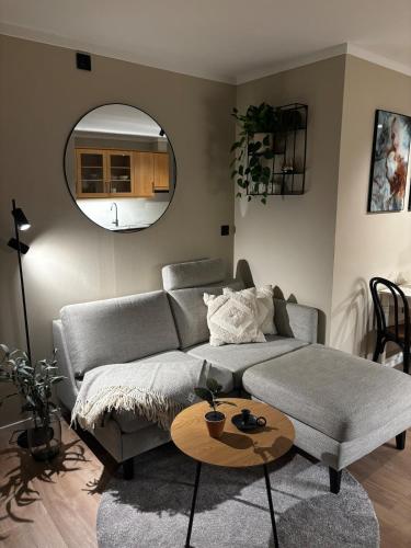 a living room with a couch and a circular mirror at Pen og moderne sentrumsleilighet in Haugesund