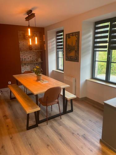 a dining room with a wooden table and chairs at La Maison Du Pavé in Villedieu-les-Poëles
