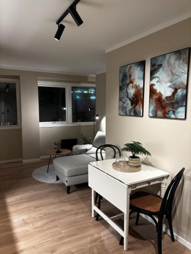 a living room with a table and a couch at Pen og moderne sentrumsleilighet in Haugesund