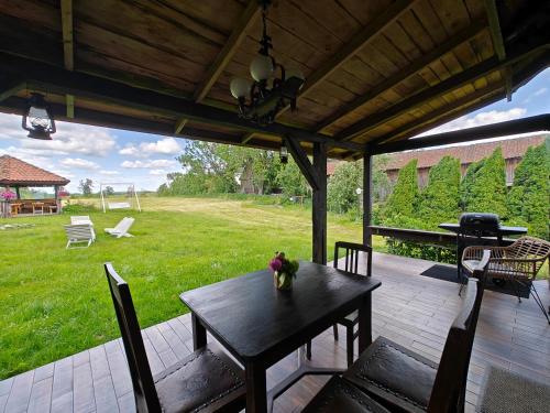 a wooden table and chairs on a patio with a yard at Stay At This Magnificent 100 Year Old Barn in Ruciane-Nida