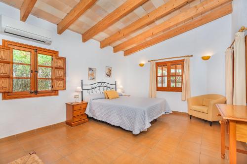 Un dormitorio con una cama, un escritorio y una silla. en Tintorer, en Puerto Pollensa