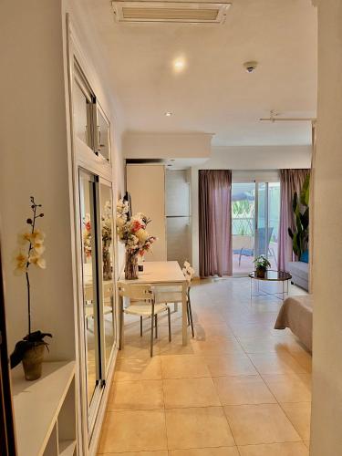 a living room with a table with flowers on it at Hotel Pyr private studio in Fuengirola