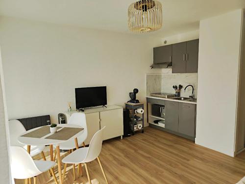 une cuisine et un salon avec une table et des chaises dans l'établissement Studio entre mer et port a Carnon plage, à Mauguio