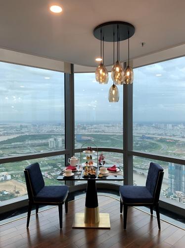 a dining room with a table and chairs and a large window at Landmark Plus Vinhomes CityView Suite in Ho Chi Minh City