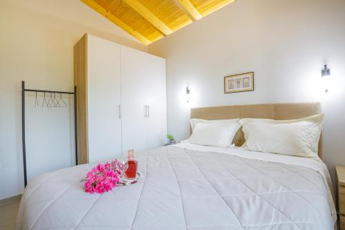 a bedroom with a large white bed with pink flowers on it at Cosy apartments in Análipsis