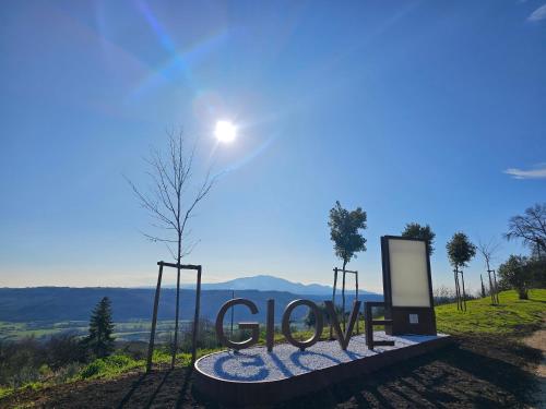 a sign that reads glory with a tree in a field at La dolce vita Giove apartment in Giove