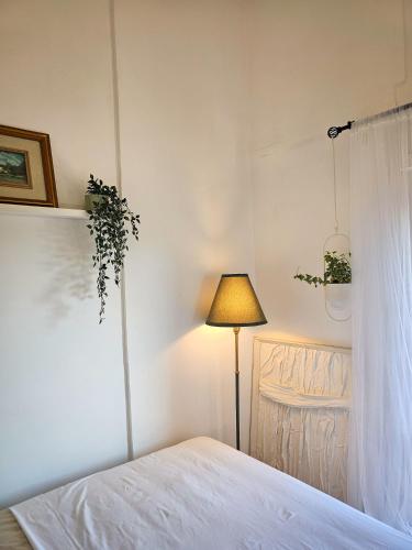 a white bedroom with a bed and a lamp at La dolce vita Giove apartment in Giove