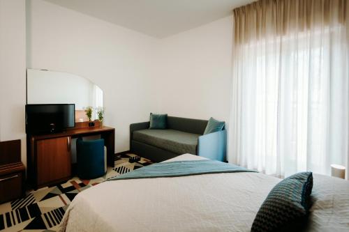 a hotel room with a bed and a couch at Hotel Eldorado in Apiro