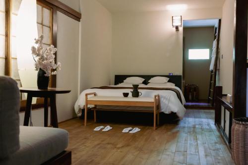 a bedroom with two beds and a table with slippers at LA TERRA narai in Shiojiri