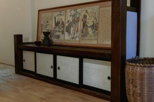a room with a wooden shelf with drawings on it at LA TERRA narai in Shiojiri