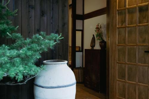 a large white vase sitting on the floor next to a door at LA TERRA narai in Shiojiri