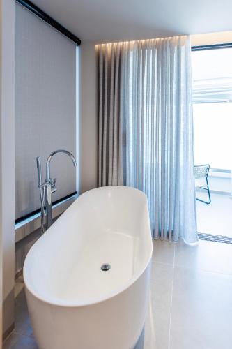 a white bath tub in a bathroom with a window at Keslin Premium Seaside Apartments in Vlorë