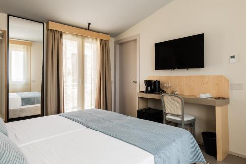 a hotel room with a bed and a desk and a television at Domus Terravecchia in Agrigento
