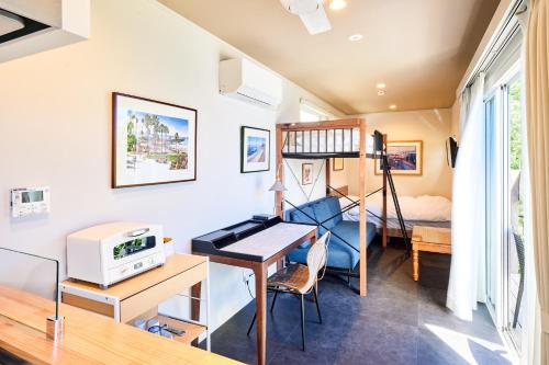 a tiny house with a desk and a bed at Surf and Sand in Onjuku