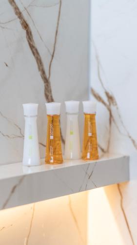 four vases sitting on a shelf in a room at Keslin Premium Seaside Apartments in Vlorë