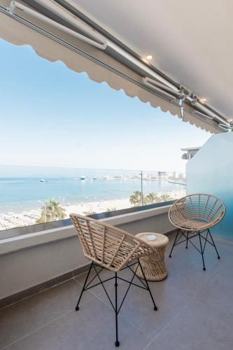 a balcony with two chairs and a view of the beach at Keslin Premium Seaside Apartments in Vlorë