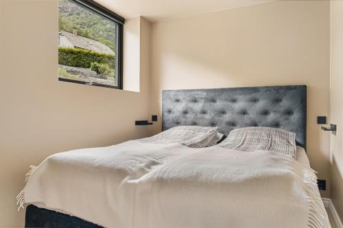 a bedroom with a large bed with a window at Odda Trolltunga Atmosphere in Odda