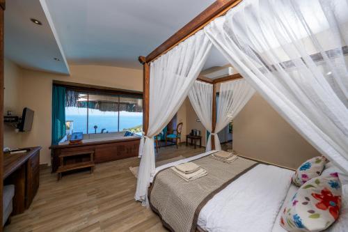 a bedroom with a bed and a tub and a window at Lissiya Hotel in Faralya