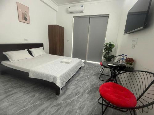 a bedroom with a bed and a red chair at Khách Sạn HƯƠNG HANA in Phúc Trì