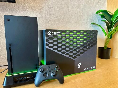 uma caixa de playstation com um controle de videogame ao lado em Amazing Sunrise Venice Grand Canal Balcony, Xbox Series X console with Game Pass Ultimate, FREE coffee, Pool, Gym & Sauna, 5 mins to BGC em Manilla